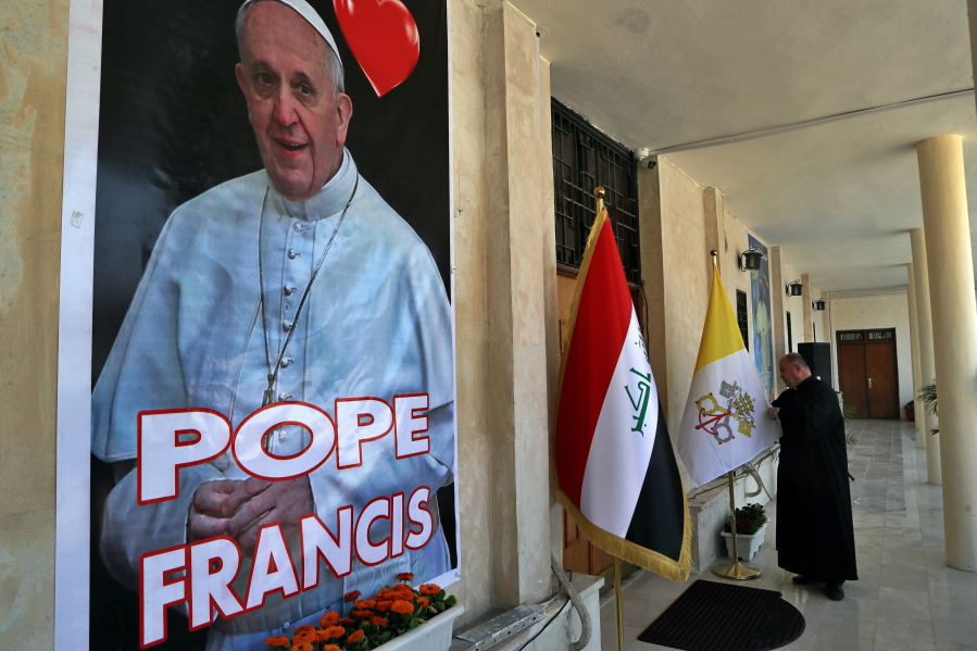 Father Nazeer Dako arranges a Vatican flag to welcome Pope Francis at St. Joseph&#039;s Chaldean Church ahead of the Pope&#039;s visit, in Baghdad, Iraq, Tuesday, March 2, 2021.