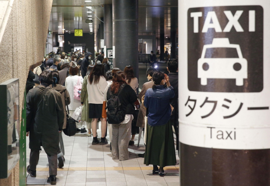 People queue up for taxi as train services are suspended following an earthquake in Sendai, Miyagi prefecture, Japan Saturday, March 20, 2021. A strong earthquake struck Saturday off northern Japan, shaking buildings even in Tokyo and triggering a tsunami advisory for a part of the northern coast.