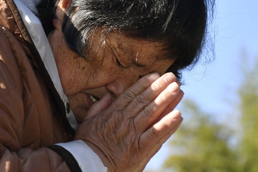 A woman who lost her husband and grandchild in the 2011 earthquake and tsunami, prays in front of the grave in Miyako, Iwate prefecture, Japan Thursday, March 11, 2021. Thursday marks the 10th anniversary of the massive earthquake, tsunami and nuclear disaster that struck Japan&#039;s northeastern coast.