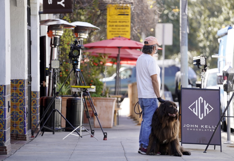 George Ruiz pets his Newfoundland dog Amy near an area on North Sierra Bonita Ave. where Lady Gaga&#039;s dog walker was shot and two of her French bulldogs stolen, Thursday, Feb. 25, 2021, in Los Angeles. The dog walker was shot once Wednesday night and is expected to survive his injuries. The man was walking three of Lady Gaga&#039;s dogs at the time but one escaped.