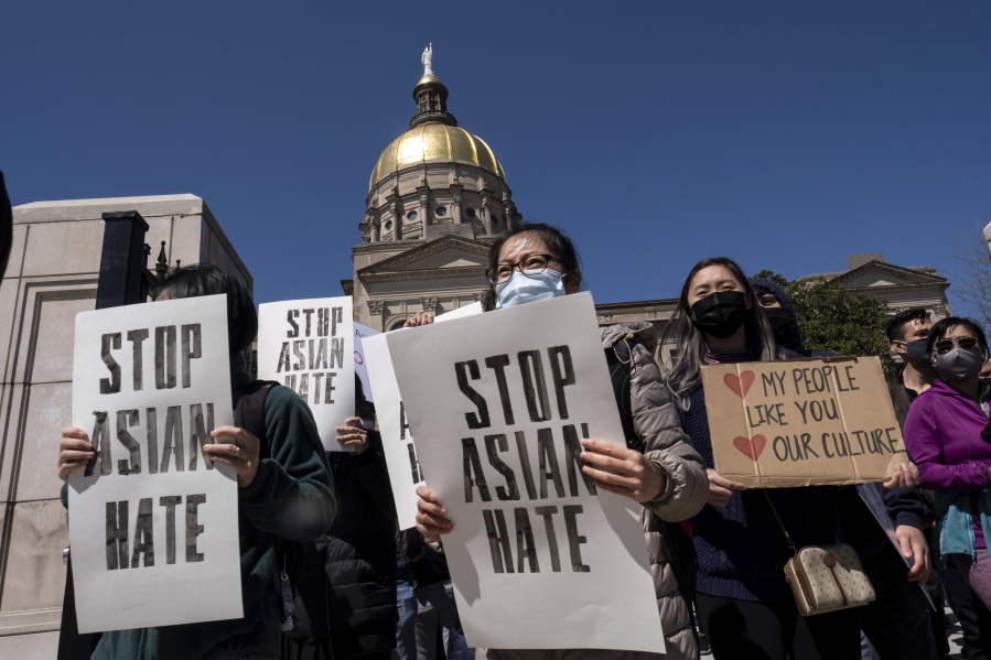 People hold signs while participating in a &quot;stop Asian hate&quot; rally outside the Georgia State Capitol in Atlanta on Saturday afternoon, March 20, 2021.