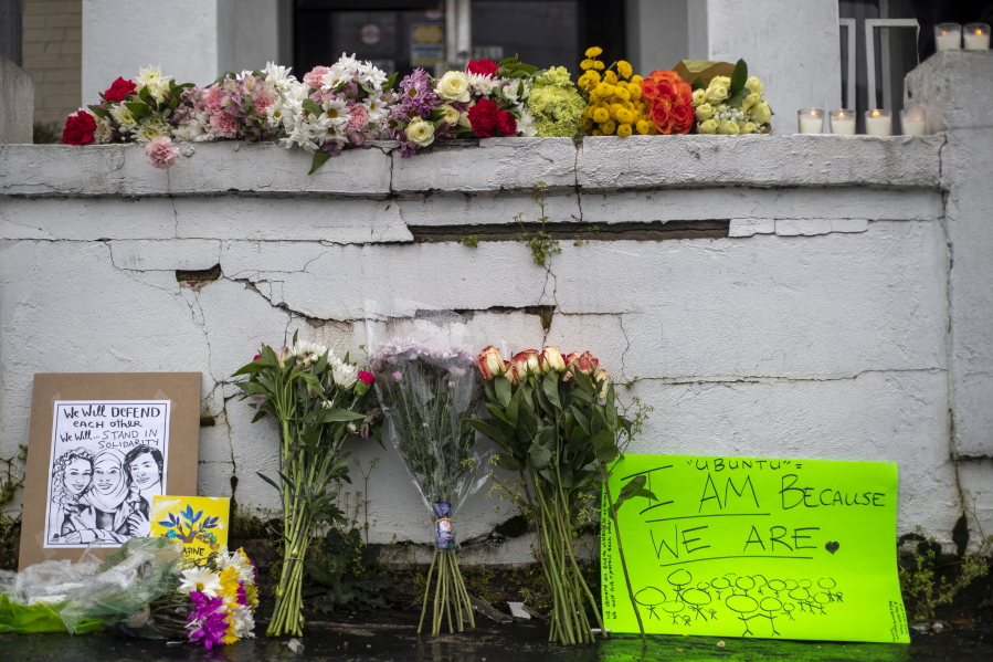 Flowers and signs are displayed at a makeshift memorial outside of the Gold Spa in Atlanta, Wednesday, March 17, 2021. Police in the Atlanta suburb of Gwinnett County say they&#039;ve begun extra patrols in and around Asian businesses there following the shooting at three massage parlors in the area that killed eight, most of them women of Asian descent.