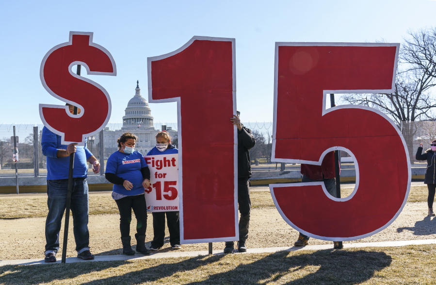 Activists appeal for a $15 minimum wage near the Capitol in Washington, Thursday, Feb. 25, 2021. The $1.9 trillion COVID-19 relief bill being prepped in Congress includes a provision that over five years would hike the federal minimum wage to $15 an hour. (AP Photo/J.