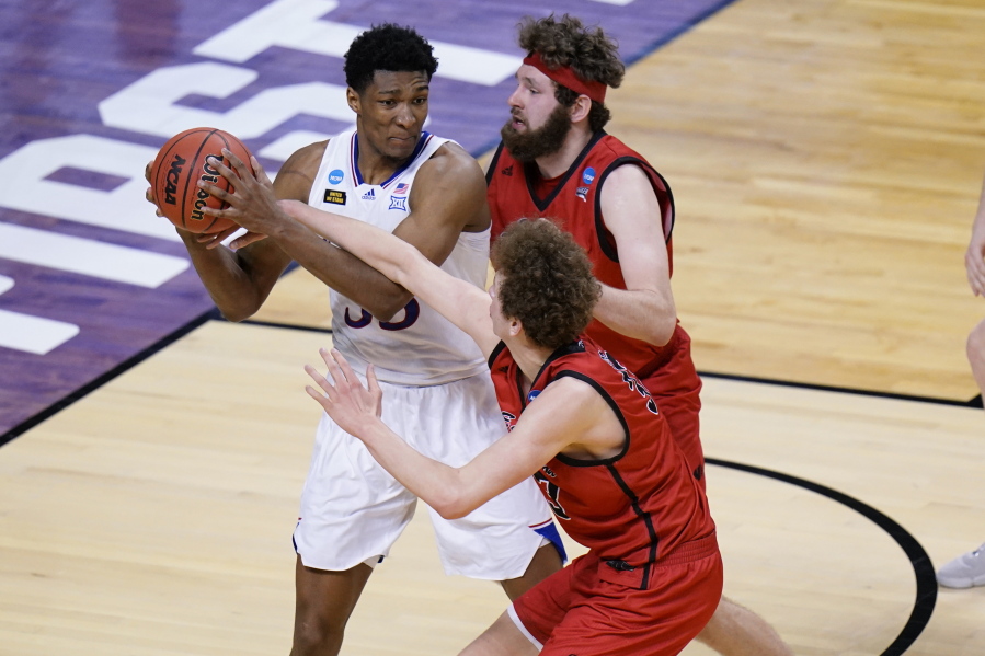 Kansas forward David McCormack, left, is pressured by Eastern Washington forward Tanner Groves, right, and teammate Eastern Jacob Groves, bottom, during the second half of a first-round game in the NCAA college basketball tournament at Farmers Coliseum in Indianapolis, Saturday, March 20, 2021.