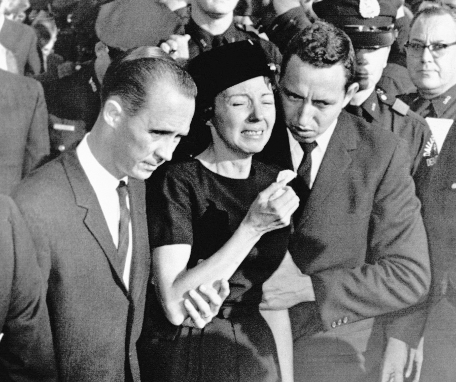 FILE - In this Monday, Nov. 25, 1963, file photo, Marie Tippit, widow of police officer J.D. Tippit who was slain during the search for President John F. Kennedy&#039;s assassin, is led weeping from Beckley Hills Baptist Church in Dallas after funeral services for her husband. Tippit who was a 35-year-old mother of three when her husband, Officer J.D. Tippit, was killed on Nov. 22, 1963, has died at age 92. Her son said she died Tuesday, March 2, 2021, at a hospital in the East Texas city of Sulphur Springs after being diagnosed with pneumonia following a positive test for COVID-19.