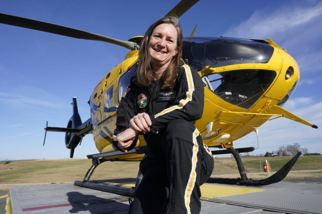Air ambulance flight paramedic, Rita Krenz, poses in front of her company&#039;s helicopter in Weyers Cave, Va., Monday, March 15, 2021. Krenz started a fund-raising campaign that brought in more than $18,000 for the charity that has helped RIP Medical Debt forgive the debt of more than 900 people so far.