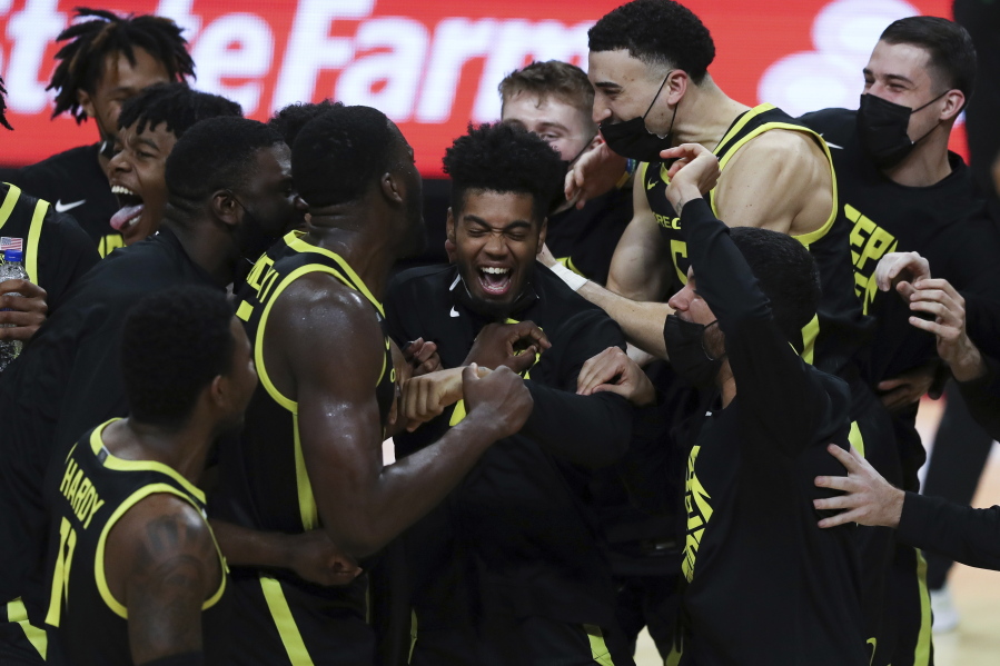 Oregon&#039;s Aaron Estrada, center, and teammates celebrate their team&#039;s win over Oregon State and their second consecutive Pac-12 regular-season conference title following an NCAA college basketball game in Corvallis, Ore., Sunday, March 7, 2021.