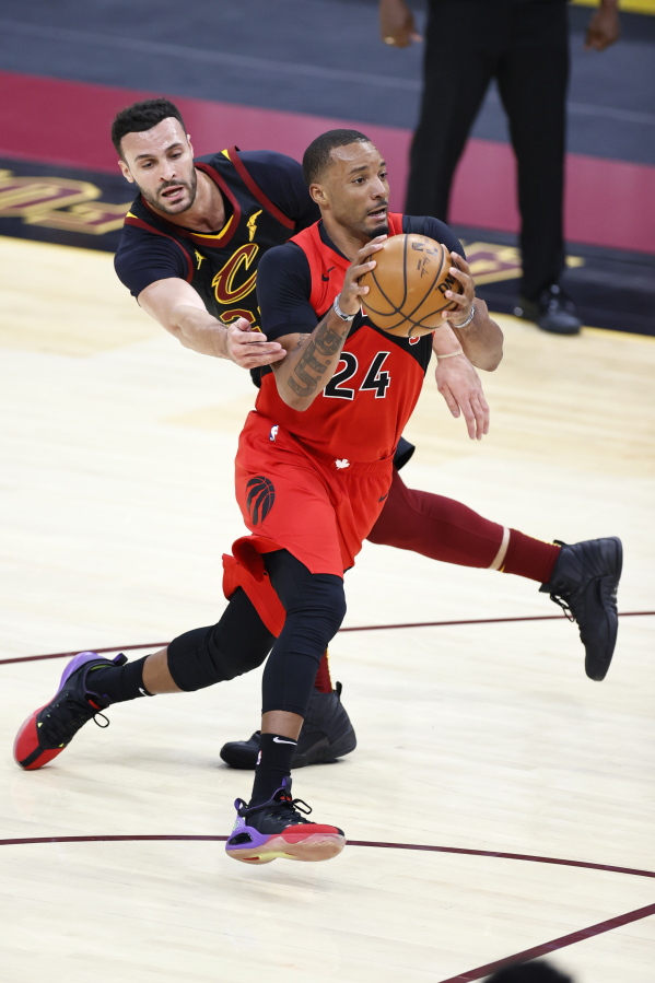 Toronto Raptors&#039; Norman Powell (24) drives past Cleveland Cavaliers&#039; Larry Nance Jr. (22) in the second half of an NBA basketball game, Sunday, March 21, 2021, in Cleveland.