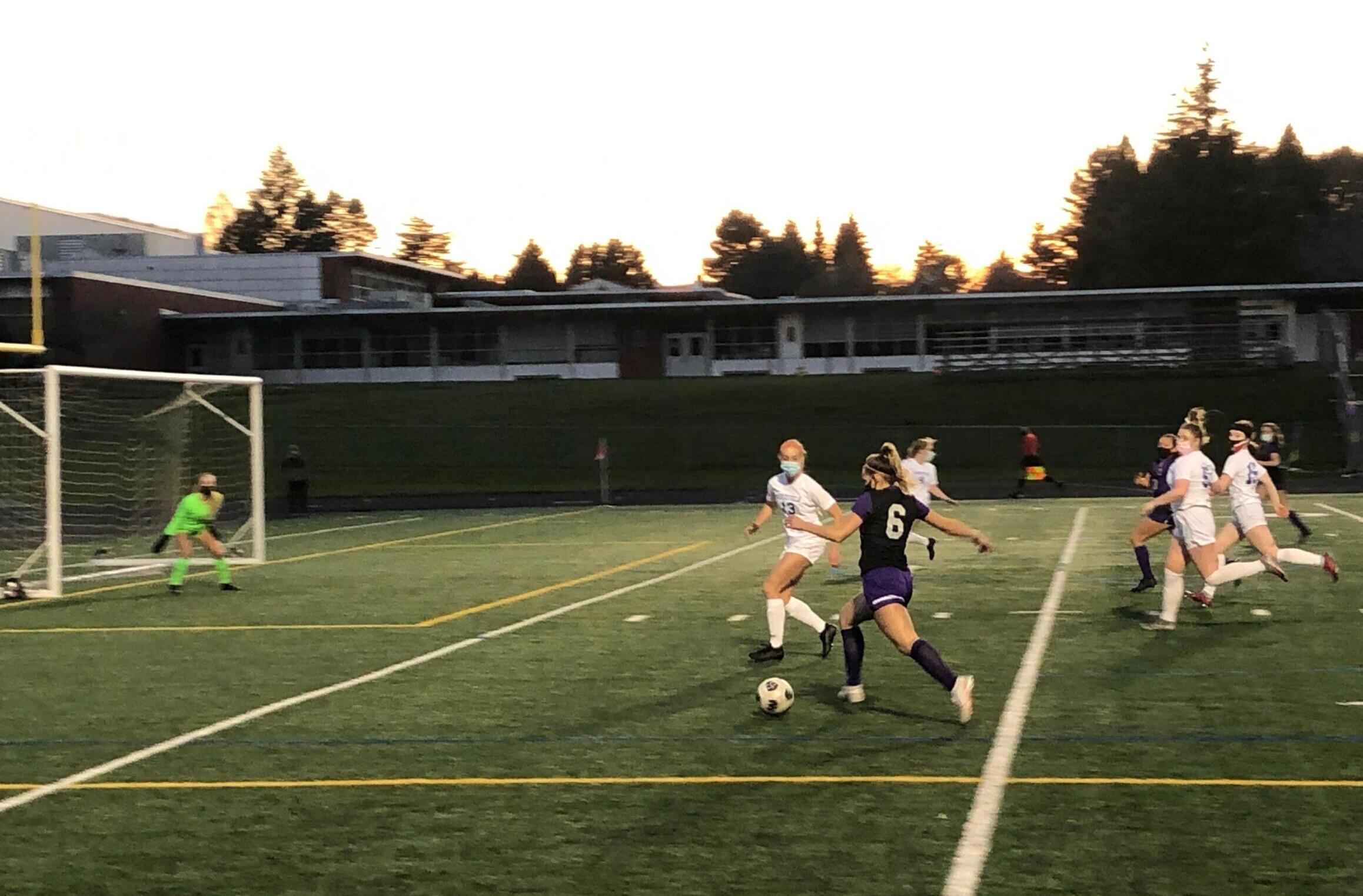 Columbia River forward Maree Seibel advances toward the goal while Cameron Jones of Ridgefield defends during a 2A district playoff game Tuesday at Columbia River High School.