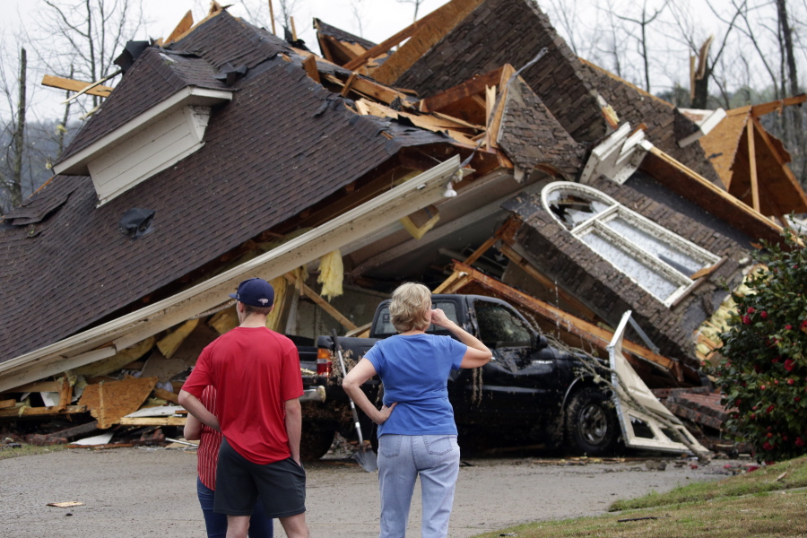 Residents survey damage to homes after a tornado touched down south of Birmingham, Ala. in the Eagle Point community damaging multiple homes, Thursday, March 25, 2021. Authorities reported major tornado damage Thursday south of Birmingham as strong storms moved through the state. The governor issued an emergency declaration as meteorologists warned that more twisters were likely on their way.