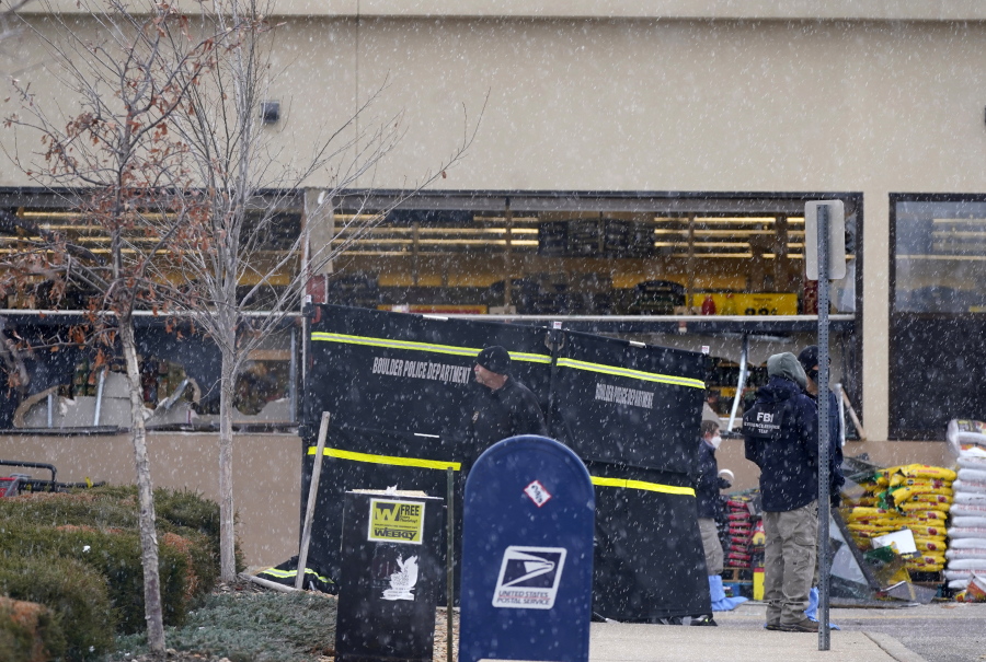 Snow falls as investigators continue to collect evidence in the parking lot where a mass shooting took place at a King Soopers grocery store Tuesday, March 23, 2021, in Boulder, Colo.