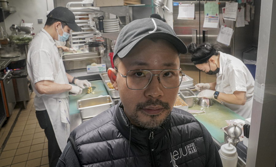 Korean American chef Douglas Kim, center, owner of the restaurant Jeju, which was vandalized during last year&#039;s racial injustice protests, is shown in the kitchen as food is being prepped, Saturday Feb. 13, 2021, in New York. Asian Americans have been facing a dangerous climate since the coronavirus entered the U.S. a year ago. A rash of crimes victimizing elderly Asian Americans in the last two months has renewed outcry for more attention from politicians and the media.
