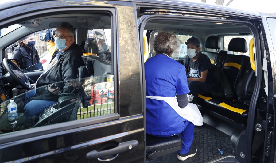 Dr Tamara Joffe prepares to administer a Covid-19 jab using the AstraZeneca vaccine to Leslie Reid in the back of a London Taxi cab during the pilot project of pop up vaccination drive &#039;Vaxi Taxi&#039; in Kilburn, London, Sunday, Feb. 28, 2021. The pilot scheme, funded by the Covid Crisis Rescue Foundation, aims to help ferry supplies and patients to temporary clinics set up in faith and community centres across the capital. People don&#039;t even need to leave the backseat if they didn&#039;t want to in order to receive their inoculation.