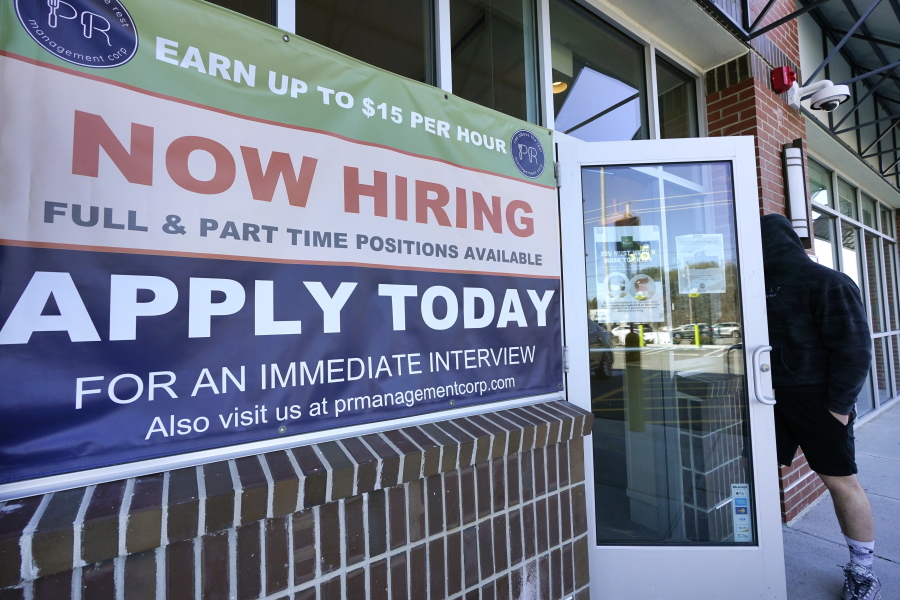 A man walks into a restaurant displaying a &quot;Now Hiring&quot; sign, Thursday, March 4, 2021, in Salem, N.H.  U.S. employers added a robust 379,000 jobs last month, the most since October and a sign that the economy is strengthening as confirmed viral cases drop, consumers spend more and states and cities ease business restrictions.