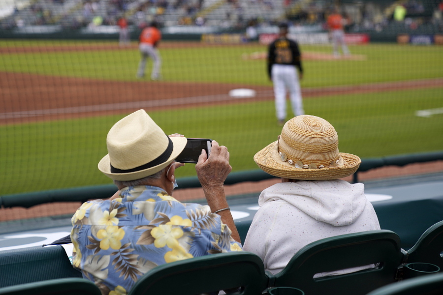 Two older adults, socially distanced, watch a spring training exhibition baseball game between the Pittsburgh Pirates and the Baltimore Orioles on Monday in Bradenton, Fla. (gene j.