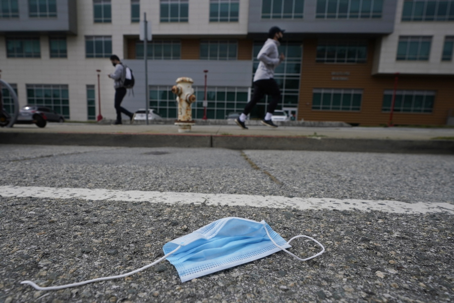 A discarded face mask lies in the street in San Francisco, Wednesday, March 17, 2021. Disposable masks, gloves and other personal protective equipment have safeguarded untold lives during the pandemic. They&#039;re also creating a worldwide environmental problem, littering streets and sending an influx of harmful plastic into landfills and oceans.