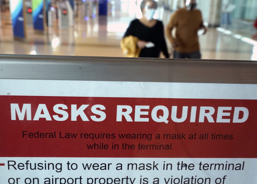 To prevent the spread of Covid-19, a sign directs travelers to wear masks at Love Field Tuesday, March 2, 2021, in Dallas.
