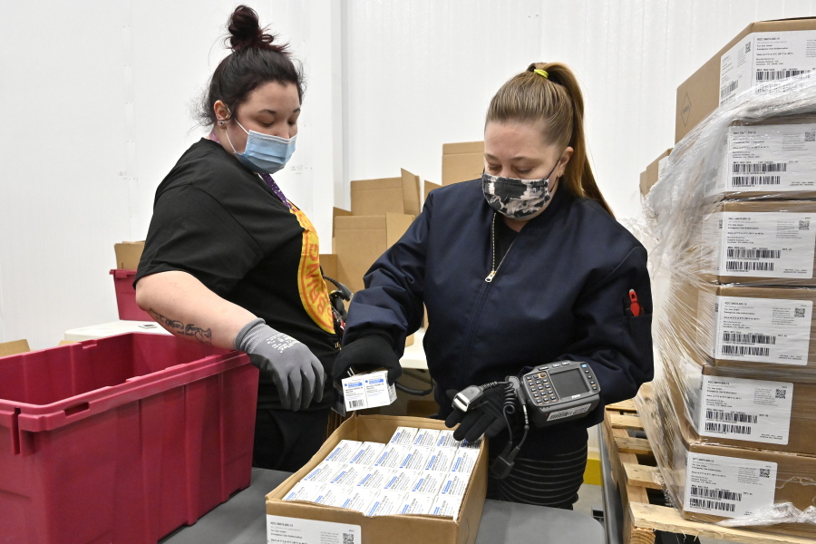 Employees with the McKesson Corporation scan a box of the Johnson &amp;  Johnson COVID-19 vaccine while filling an order at their shipping facility in Shepherdsville, Ky., Monday, March 1, 2021. (AP Photo/Timothy D.