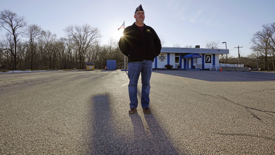 Craig DeOld, commander at Veterans of Foreign War Post #1018, stands in the post&#039;s empty parking lot as the sun sets, Monday, March 15, 2021, in Boston. Local bars and halls run by VFW and American Legion posts have fallen on hard times during the coronavirus pandemic. Organizers say many risk permanent closure after states ordered them, like other bars and halls, to shutter last spring.