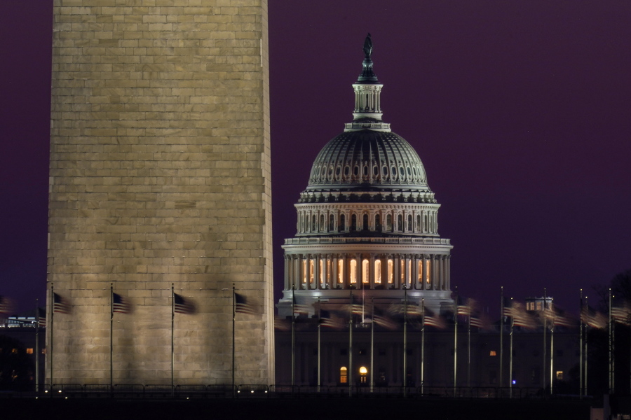 The Capitol is seen beyond the base of the Washington Monument before sunrise in Washington, Wednesday, March 10, 2021.