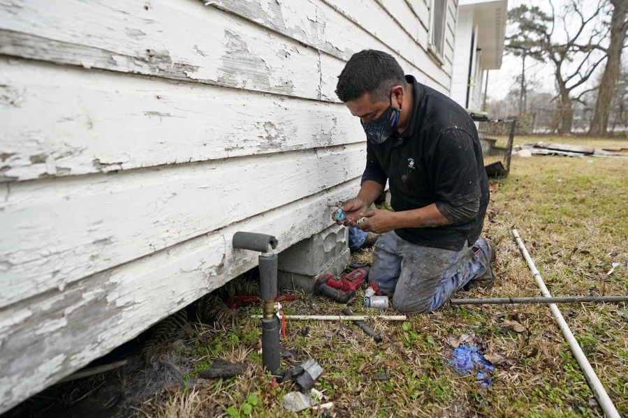 West Street Recovery&#039;s Johnny Vicar works to repair busted pipes under a home, that were frozen during the recent winter storm, Thursday, Feb. 25, 2021, in Houston. West Street Recovery, a nonprofit created in the wake of Hurricane Harvey to help repair flood damaged homes, has been working since the winter storm hit to repair and replace damaged plumbing systems for residents who can&#039;t afford to do so. (AP Photo/David J.