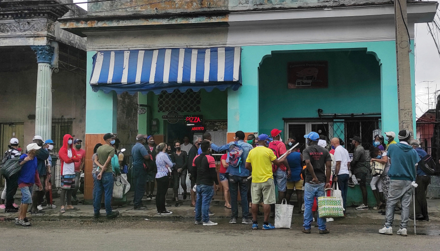 People wearing face masks as a precautionary measure against the spread of the novel coronavirus, COVID-19, queue to buy food in Havana, Cuba on March 22, 2021.