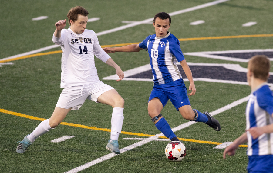 La Center's Angel Merino (10) dribbles past Seton Catholic's Dennis Babiy (14) during a Trico League matchup last week. Merino, an exchange student from Madrid, Spain, is receiving a truly American experience through high school sports.