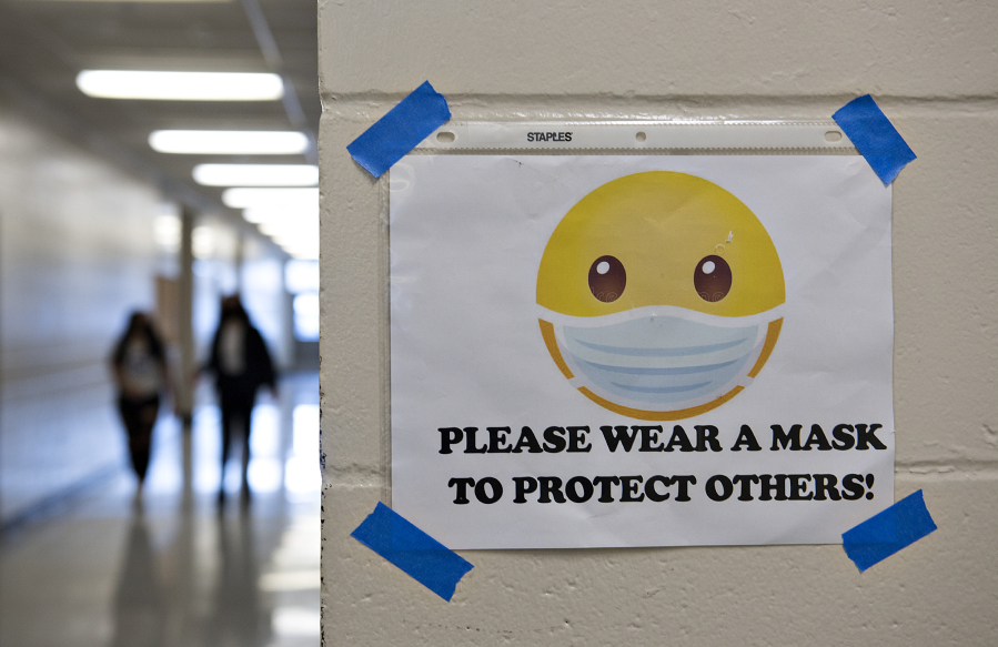 A sign encourages students and staff to wear their masks in a hallway at Heritage High School on March 4.