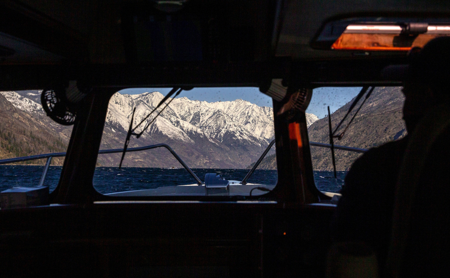 Mountains of the North Cascades in the distance as Ray Eickmeyer and Mistaya Johnston travel by boat to vaccinate those at Holden Village, Stehekin and workers at a mine remediation water treatment plant operated by Rio Tinto, on Tuesday, March 30, 2021.