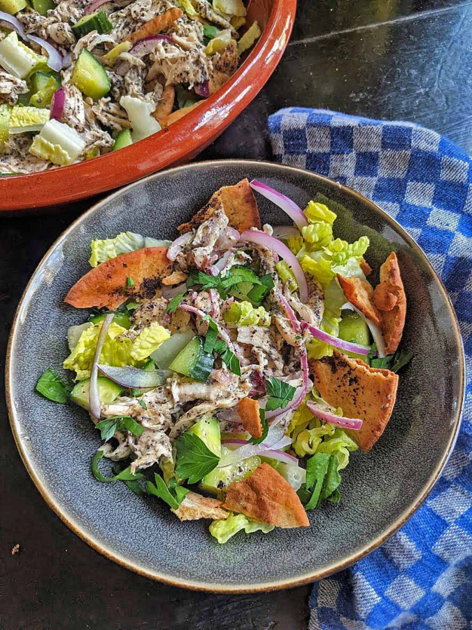 Fattoush is a chopped Levantine salad made with stale pita. This includes shredded chicken tossed in a citrusy tahini-sumac dressing.