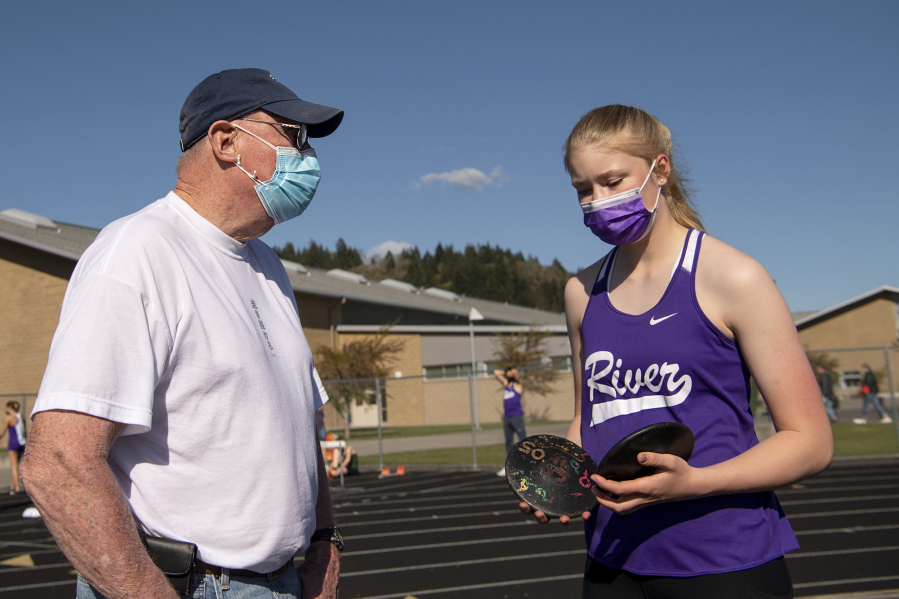 Columbia River volunteer coach Rick Sloan instructs freshman Logan DeJong, his eldest granddaughter, during a 2A Greater St. Helens League meet at Woodland High School. Sloan, 74, was a participant at the 1968 Summer Olympics in Mexico City, placing seventh in the decathlon. He went on to have a 41-year coaching career at Washington State.