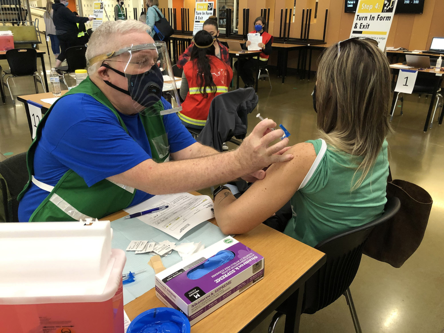 Jack Stump injects COVID-19 vaccine at a vaccination clinic at Woodland High School.