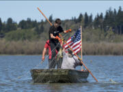 Conan Reutov, left, hauls a carp out of Vancouver Lake on Wednesday with the help of Arty Kuzmin.