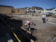 Russell Hines of Brothers Concrete Inc., foreground, helps to build a triplex at the 2 Creeks development in Camas on Wednesday. Clark County's housing market is facing a record low supply, and industry professionals say it's not that new listings have dried up or the pace of building has slowed down - it's just that there's no way to keep up with the current level of demand.