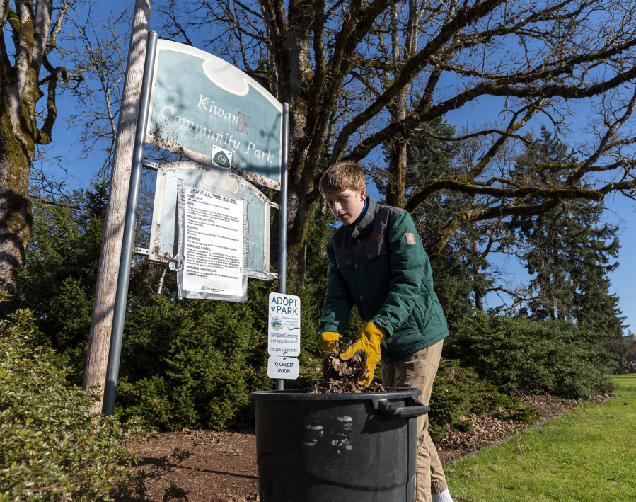 Zac French, 14, of Battle Ground puts leaves and other debris into a trash can Saturday at Kiwanis Park during Battle Ground's Park Appreciation Day.