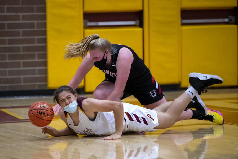 Prairie’s Alysia Fraly, bottom, falls to the ground after colliding with Union’s Ariel Ammentorp while they battled for a rebound in a 4A/3A Greater St. Helens League girls basketball game on Thursday, April 22, 2021, at Prairie High School. Union won 50-46.