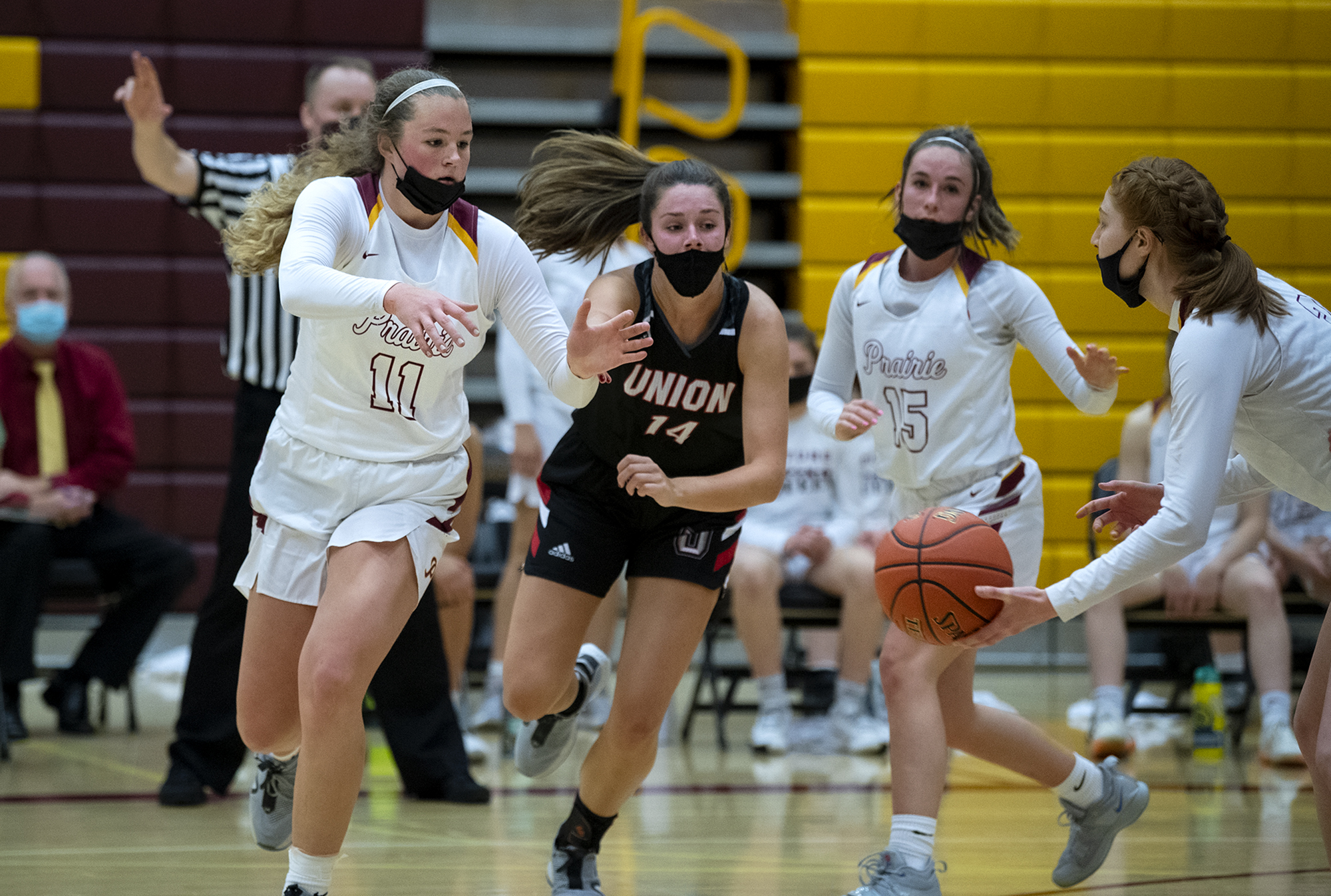 Prairie’s Claire Heitschmidt fights off the defense of Union’s Kaneyl Carpenter to get a handoff from Kaitlyn Caughey in a 4A/3A Greater St. Helens League girls basketball game on Thursday, April 22, 2021, at Prairie High School. Union won 50-46.