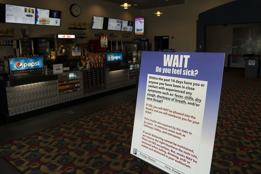 A sign in the entryway alerts customers to COVID-19 restrictions at Battle Ground Cinema. Clark County movie theaters are reopening, but owners are still waiting on a federal grant program intended to help them stay afloat.