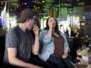 Vancouver residents Josh Golliday, left, and his sister Katherine Golliday take jello shots at Vault 31 Bar in Vancouver. Vault 31 is giving away free jello shots to guests who can prove they have received a COVID-19 vaccination. A vaccination card or a selfie of getting vaccinated both serve as proof.