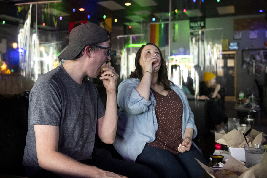 Vancouver residents Josh Golliday, left, and his sister Katherine Golliday take jello shots at Vault 31 Bar in Vancouver. Vault 31 is giving away free jello shots to guests who can prove they have received a COVID-19 vaccination. A vaccination card or a selfie of getting vaccinated both serve as proof.