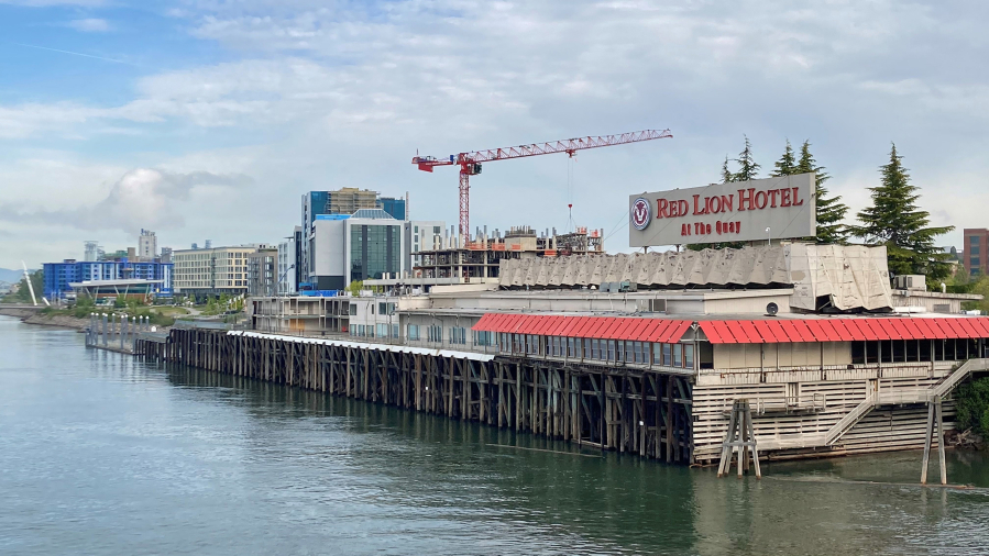 New development along the Vancouver waterfront rises behind the former Red Lion Hotel at the Quay on Wednesday morning. The Washington Legislature has provided $1 million to demolish the landmark building as part of the Port of Vancouver's Terminal 1 redevelopment project.