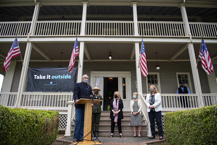 Gov. Jay Inslee talks to members of the media during a press conference about the "Take It Outside" program to prevent disease transmission. Also pictured are Tracy Fortmann, second from left, superintendent of Fort Vancouver National Historic Site, Stacey Graham, with scarf, interim president of The Historic Trust, Liz Luce of Friends of Fort Vancouver Historic Site and Vancouver Mayor Anne McEnerny-Ogle.