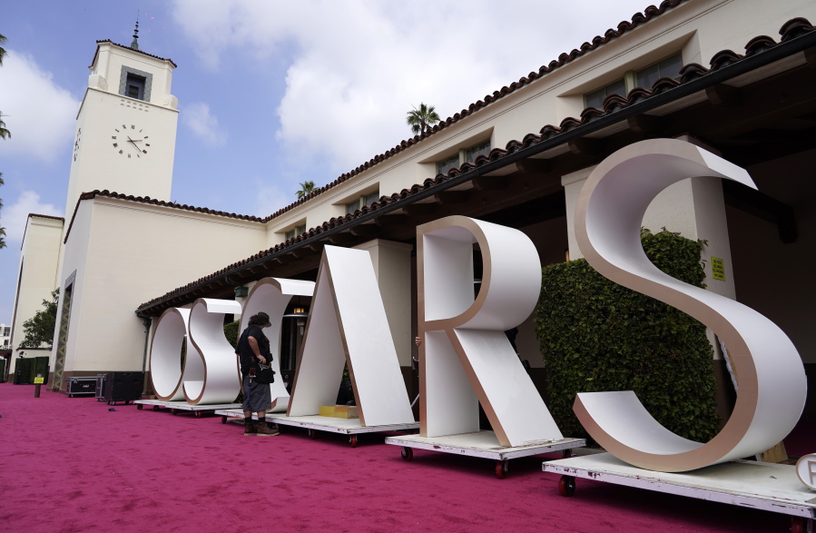 An Academy Awards crew member looks over a background element for the red carpet at Union Station, one of the locations for Sunday's 93rd Academy Awards, Saturday, April 24, 2021, in Los Angeles.