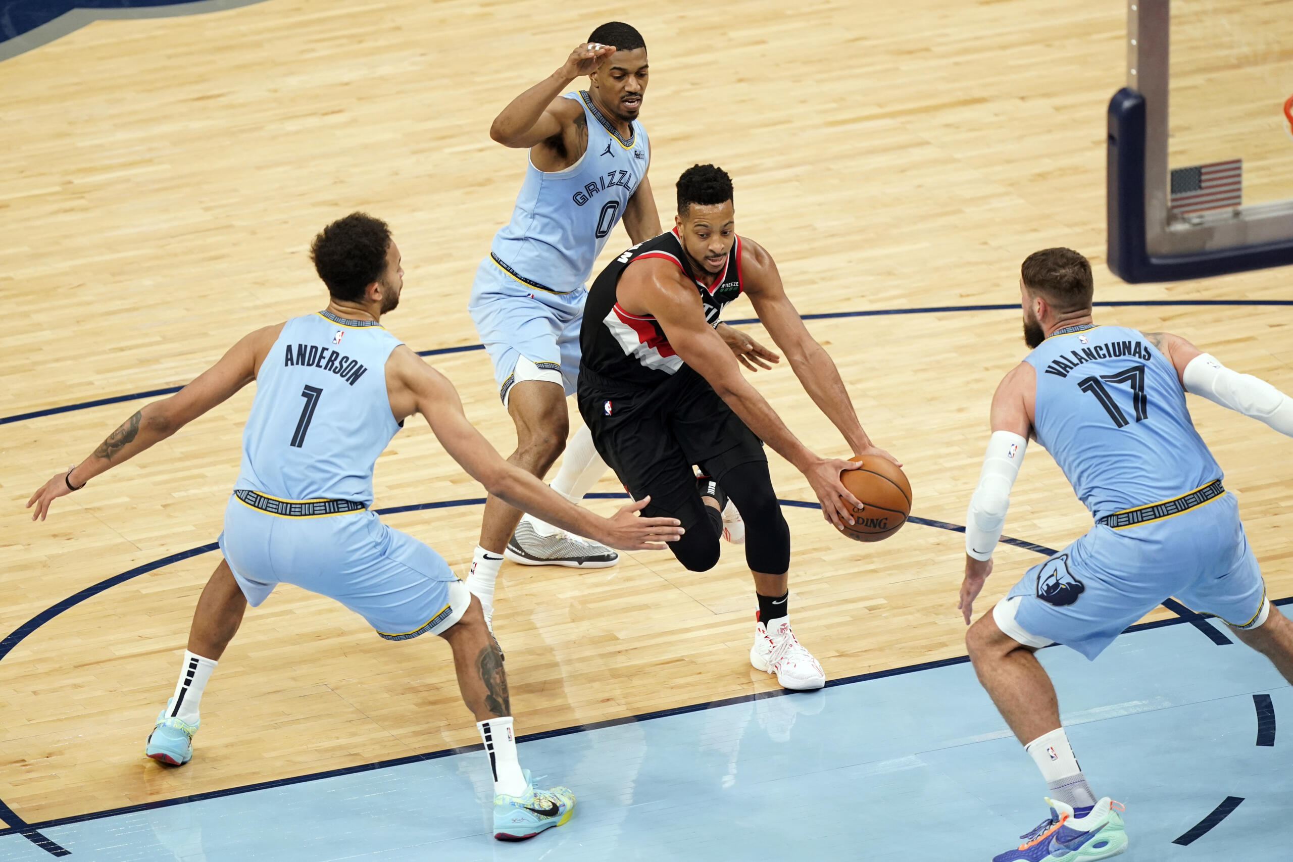 Portland Trail Blazers' CJ McCollum, center, drives between Memphis Grizzlies' defenders Kyle Anderson (1), De'Anthony Melton (0) and Jonas Valanciunas (17) in the second half of an NBA basketball game Wednesday, April 28, 2021, in Memphis, Tenn.