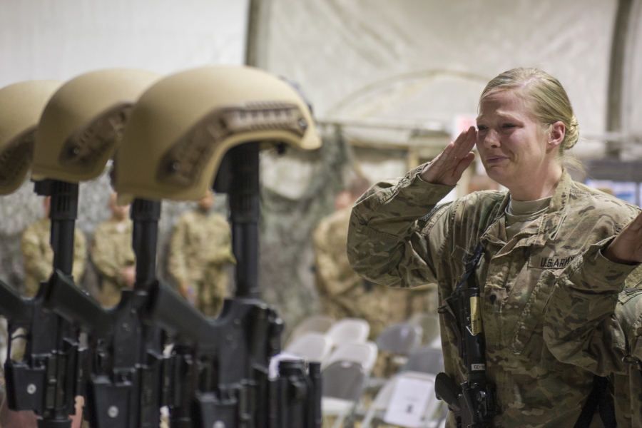 FILE - In this Dec. 23, 2015 file photo, a U.S. service member salutes her fallen comrades during a memorial ceremony for six Airmen killed in a suicide attack, at Bagram Air Field, Afghanistan. ter 20 years America is ending its "forever" war in Afghanistan. There's conflicting views even among U. S. military minds as to  whether the time is right. For others there is another lingering question: Was it worth it? (Tech. Sgt. Robert Cloys/U.S.