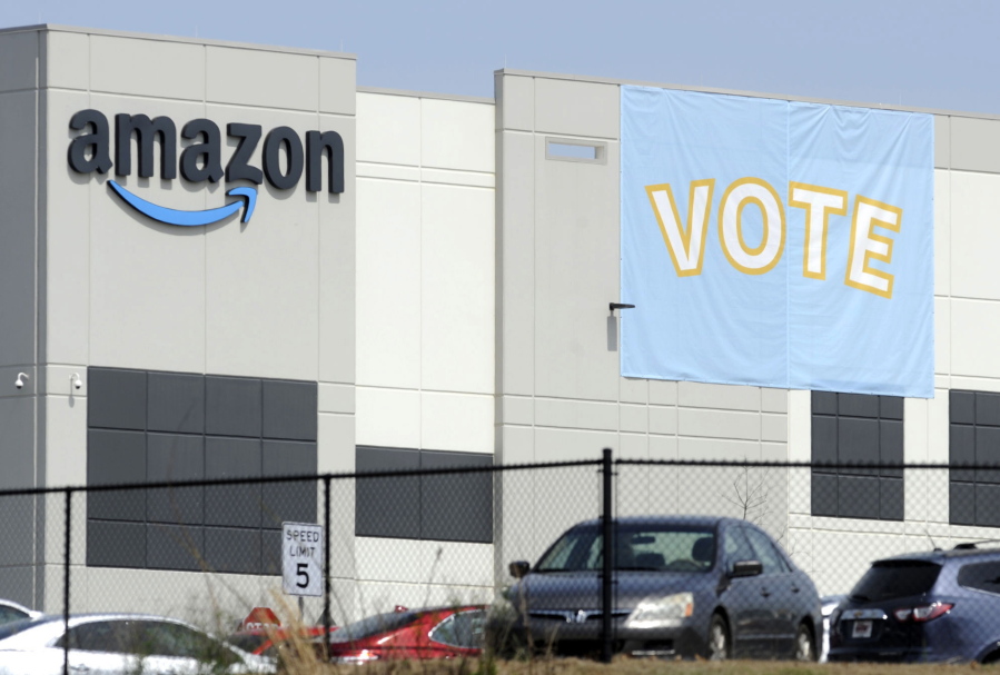 FILE - In this March 30, 2021 file photo, a banner encouraging workers to vote in labor balloting is shown at an Amazon warehouse in Bessemer, Ala.  The retail union that failed to unionize Amazon workers at the Alabama warehouse wants the results to be thrown out, saying that the company illegally interfered with the voting process.The Retail, Wholesale and Department Store Union said in a filing that Amazon threatened workers with layoffs and even the closing of the warehouse if they unionized.