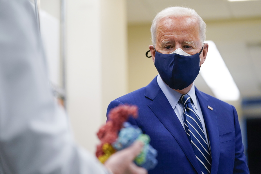 FILE - In this Feb. 11, 2021, file photo President Joe Biden looks at a model of Covid-19 as he visits the Viral Pathogenesis Laboratory at the National Institutes of Health in Bethesda, Md.