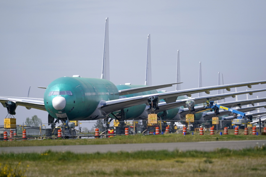 A line of Boeing 777X jets are parked nose to tail on an unused runway at Paine Field, near Boeing's massive production facility, Friday, April 23, 2021, in Everett, Wash.  Boeing Co. on Wednesday, April 28,  reported a loss of $537 million in its first quarter. The Chicago-based company said it had a loss of 92 cents per share. Losses, adjusted for non-recurring gains, were $1.53 per share.