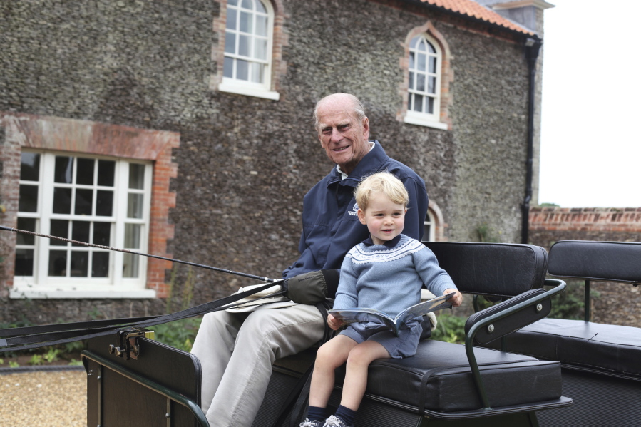 In this undated handout photo provided by the Duke and Duchess of Cambridge, Britain&#039;s Prince Philip sits with his great-grandson Prince George in England. Prince Philip, the irascible and tough-minded husband of Queen Elizabeth II who spent more than seven decades supporting his wife in a role that mostly defined his life, died on Friday, April 9, 2021.