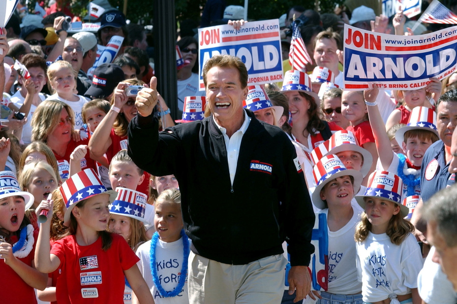 FILE - In this Oct. 5, 2003, file photo, then-Republican candidate for California governor Arnold Schwarzenegger walks up the steps to the state Capitol surrounded by children and waving to supporters during a campaign rally in Sacramento, Calif. No candidate of Schwarzenegger's fame has yet emerged in the expected 2021 recall election against Democratic Gov. Gavin Newsom.
